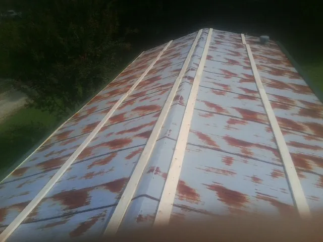 Rusted metal roof panels with new wood purlins before replacement — Storm Damage Roof Repair in Pollock by Roofing Brothers