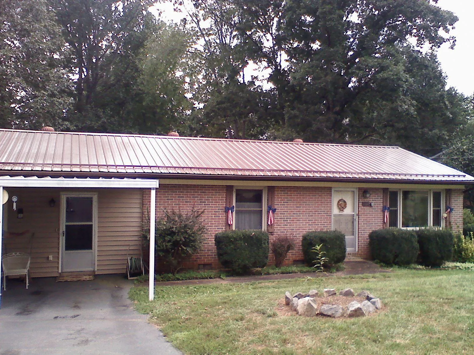 Bronze metal roof and carport on a brick ranch home — Roof Repair work by our crew in Pollock